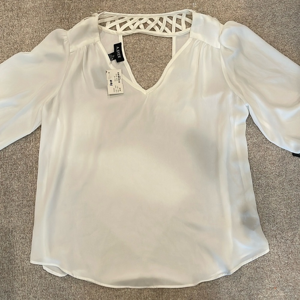 Women’s size medium 100% polyester shirt.  White with a v-neck.